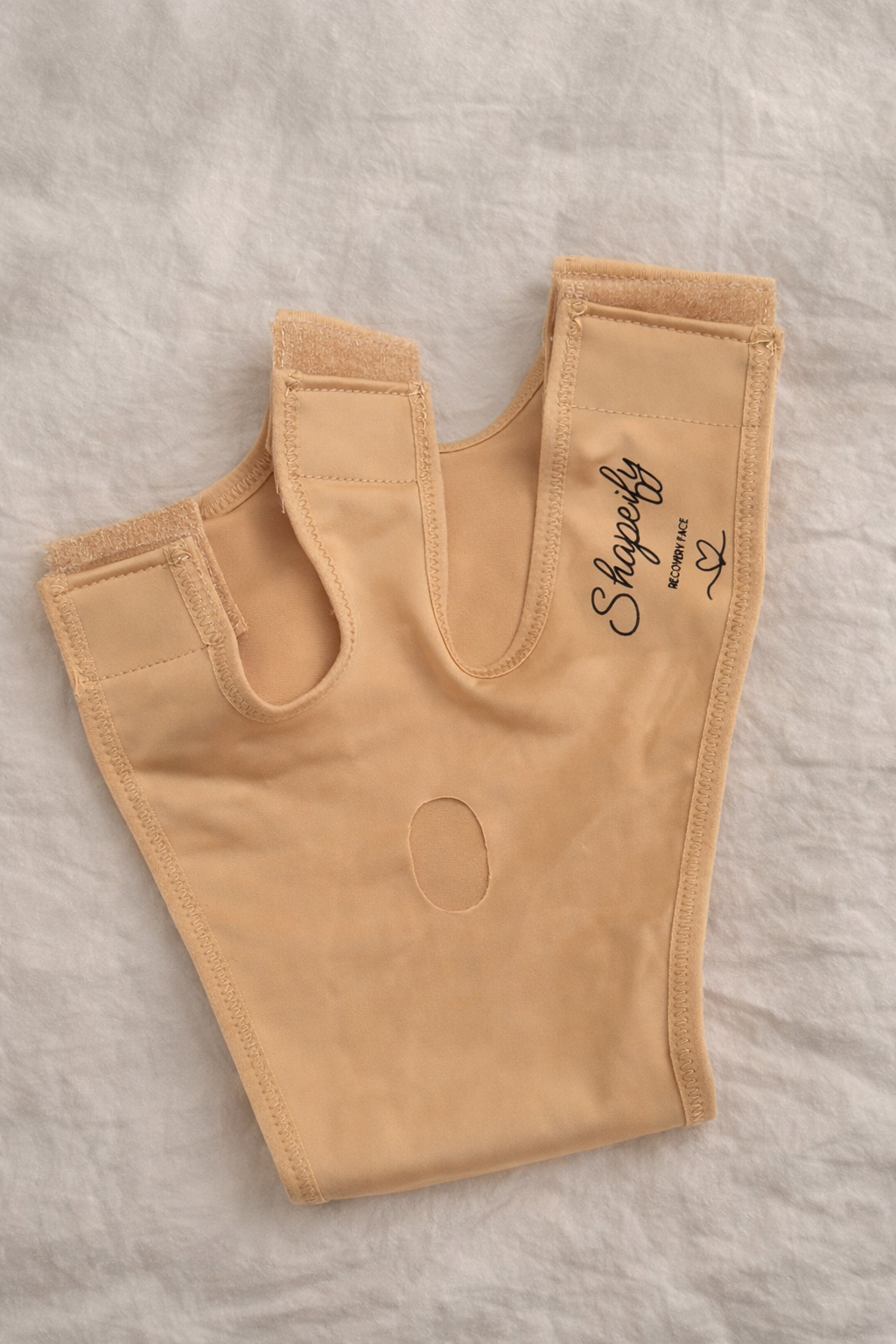 bilde av stoff på Shapeify Recovery Face Mask i beige som viser glatt og elastisk kompresjonsmateriale